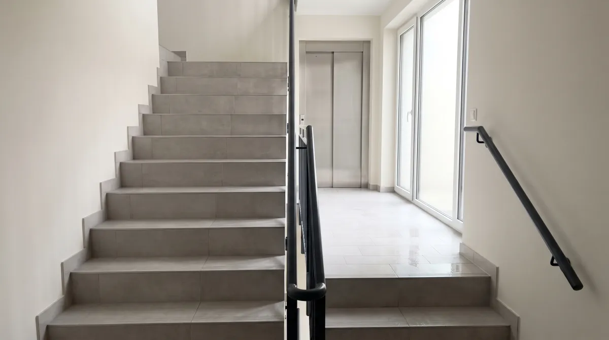 Treppenhaus im Neubau mit frisch gewischten Fliesen in Düsseldorf
